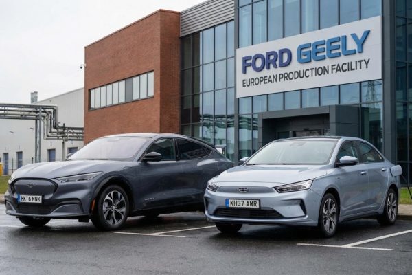 Ford and Geely electric vehicles positioned at a European manufacturing plant exterior